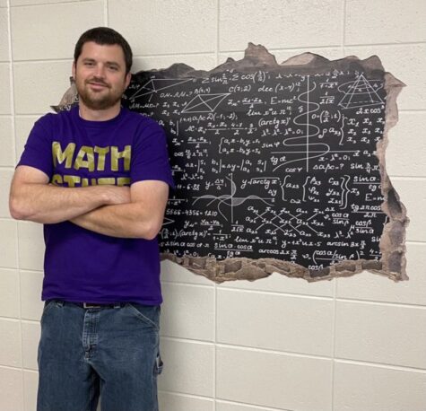 Mr. McWilliams in front of his math equation wall