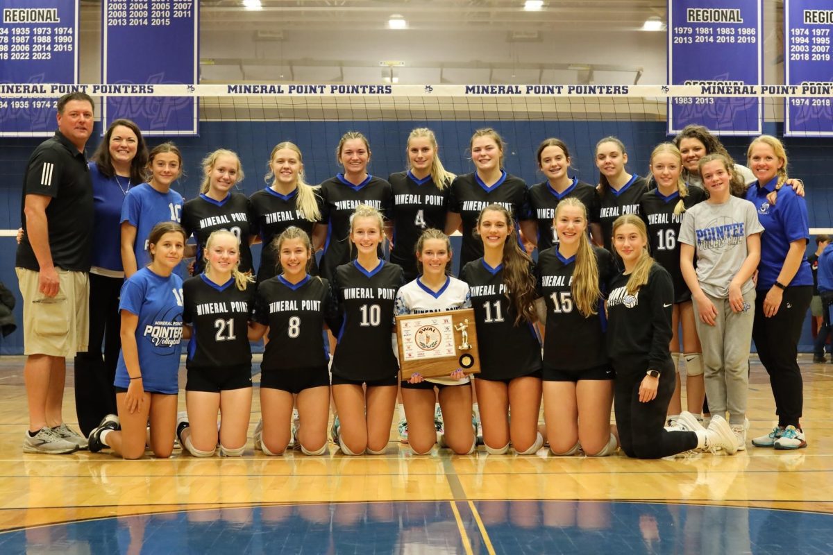 The Pointer volleyball team smiling with their conference champ plaque.